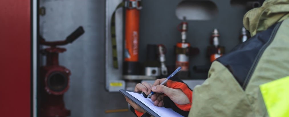 Fireman near the fire truck listing equipment